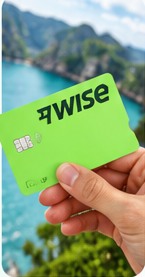 Green Wise debit card against a coastal background